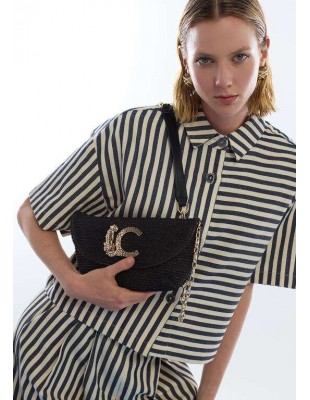 Bolso trenzado con solapa y cadena LC de LOLA CASADEMUNT - modelo sujeta el bolso negro colgado al hombro