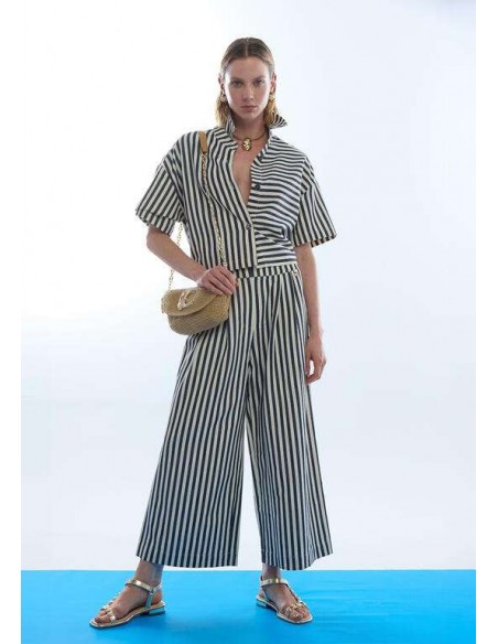 Bolso trenzado con solapa y cadena LC de LOLA CASADEMUNT - modelo de pie sujeta el bolso beige