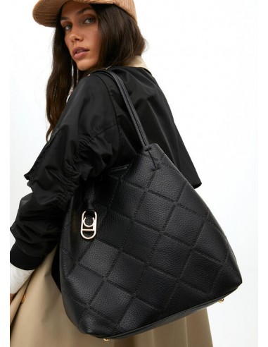 Modelo lleva colgado del hombro el bolso shopper negro efecto piel con logo LC de Lola Casademunt