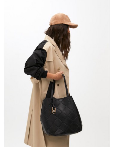 Modelo lleva en la mano el bolso shopper negro efecto piel con logo LC de Lola Casademunt