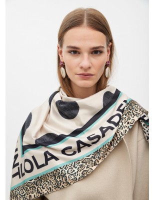 Pañuelo Lola Casademunt con Topos y Logo Animal Print - modelo sostiene el pañuelo abierto en su espalda. 2