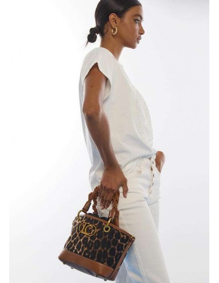 Mini Capazo Leopardo con Asas Trenzadas – Lola Casademunt - modelo vestida de blanco lleva el bolso - vista lateral